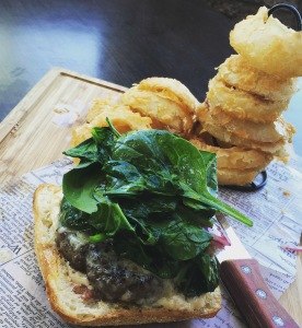 Kobe Beef Burger: open faced on ciabatta bread, aged white cheddar, sauteed spinach & onions with a garlic aioli. Onion rings. 